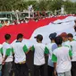 Massa demonstran membentangkan bendera merah putih raksasa di depan Istana Merdeka. Mereka mendesak Jokowi segera melantik pimpinan baru KPK. (Istimewa)