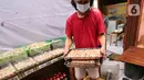Karyawan membawa dimsum untuk kukus di Griya Dimsum Bunda Imoet, Serua, Tangerang Selatan, Rabu (9/2/2022). UMKM dimsum yang berdiri sejak tahun 2020 di awal pandemi mampu memproduksi lebih dari 100 pak atau lebih dari 1000 buah dimsum per hari. (Liputan6.com/Fery Pradolo)