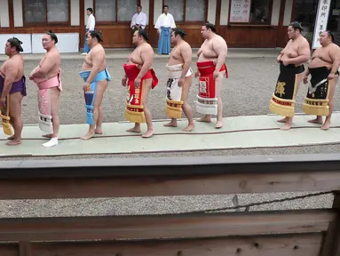 Sejumlah pegulat sumo berbaris untuk berdoa di Kuil Yasukuni di Tokyo, Jepang, Senin (17/4). (AP Photo / Shizuo Kambayashi)