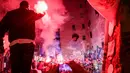 Orang-orang menyalakan suar saat mereka berkumpul di depan mural raksasa Diego Maradona untuk memberi penghormatan dan memperingati mendiang legenda sepak bola di hari ulang tahunnya di Naples, Italia, 30 Oktober 2022. Legenda sepak bola asal Argentina, Diego Armando Maradona yang lahir pada 30 Oktober 1960 meninggal pada 25 November 2020. (Alessandro Garofalo/LaPresse via AP)