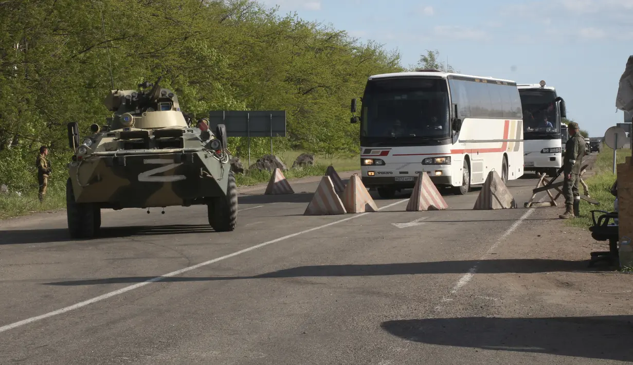 Bus-bus dengan prajurit Ukraina yang dievakuasi dari pabrik baja Azovstal Mariupol yang terkepung melakukan perjalanan ditemani oleh APC Rusia ke sebuah penjara di Olyonivka, wilayah di bawah pemerintahan Republik Rakyat Donetsk, Ukraina timur (17/5/2022). (AP Photo)