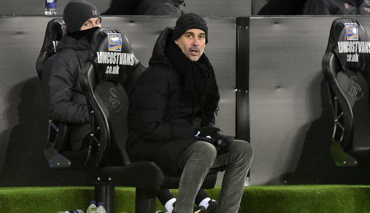 Manajer tim Manchester City, Pep Guardiola mengamati penampilan timnya menghadapi Swansea City dalam laga babak kelima Piala FA 2020/21 di Liberty Stadium, Rabu (10/2/2021). Manchester City menang 3-1 atas Swansea City. (AFP/Rebecca Naden/Pool)