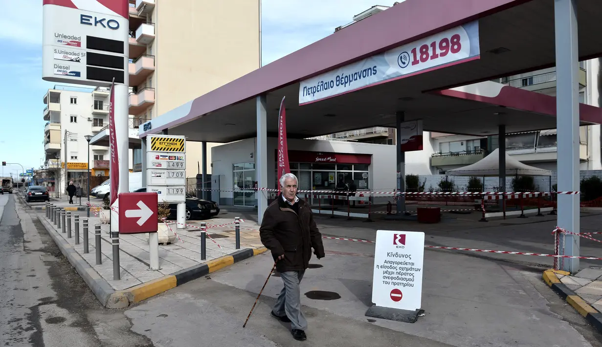 Seorang pria melintas dekat lokasi ditemukannya bom dari masa Perang Dunia II di Kota Thessaloniki, Yunani, 9 Februari 2017. Evakuasi penuh pun dilakukan terhadap seluruh warga yang tinggal di radius 1,9 km dari lokasi bom ditemukan (SAKIS MITROLIDIS/AFP)