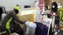 Hanan Yousef (35) memeriksa koper-kopernya untuk perjalanan wisata ke Mesir, di Bandara Internasional King Abdulaziz, Jeddah, Senin (177/5/2021). Warga Saudi yang telah menerima vaksinasi Covid-19 diizinkan bepergian ke luar negeri menyusul dicabutnya larangan perjalanan. (AP Photo/Amr Nabil)