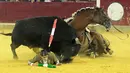 Matador asal Perancis, Lea Vicens tergeletak bersama kudanya setelah digulingkan oleh banteng selama acara El Pilar Feria di La Misericordia, sebuah arena adu banteng pada 16 Oktober 2016. / (AFP PHOTO / Alberto Simon)