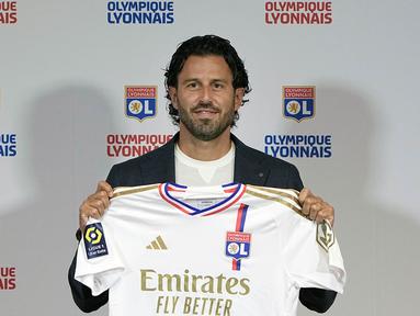 Pelatih kepala baru Lyon, Fabio Grosso, dari Italia berpose dengan jersey tim di akhir konferensi pers untuk mengumumkan kedatangannya, di Stadion Groupama di Decines, dekat Lyon, Prancis tengah, Senin, 18 September 2023. (AP Photo/Laurent Cipriani)
