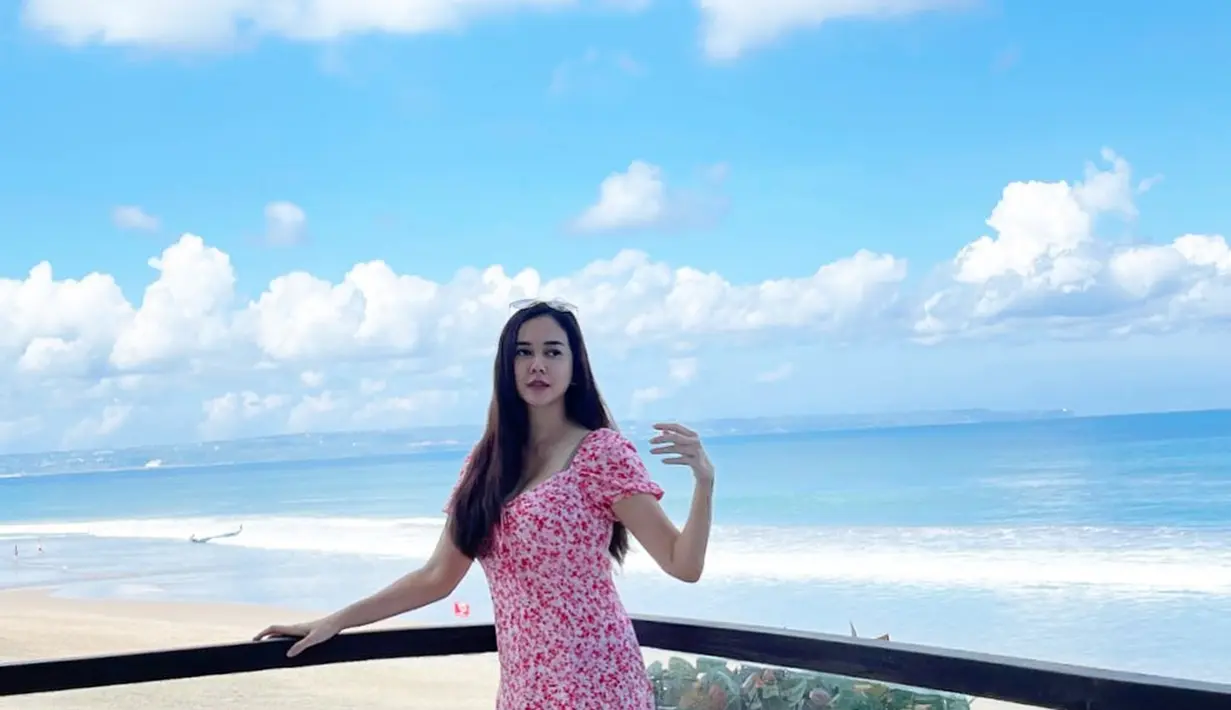 Floral dress warna cerah jadi pilihan outfit yang nyaman dan stylish saat ke pantai. [Instagram/aurakasih]