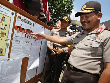 Kapolri Jendral Badrodin Haiti saat melihat papan tata cara pencoblosan di TPS Kampung Pilkada RW 03, Depok, Jawa Barat, Rabu (9/12). Kapolri turun langsung ke lapangan untuk memastikan kelancaran Pilkada. (Liputan6.com/Immanuel Antonius)