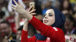 Fans wanita bermain ponsel sebelum pertandingan Piala Super Eropa 2019 antara Liverpool melawan Chelsea di Besiktas Park, Istanbul, Turki (14/8/2019). Dalam pertandingan ini Liverpool menang atas Chelsea lewat drama adu penalti 5-4 (2-2). (AP Photo/Thanassis Stavrakis)