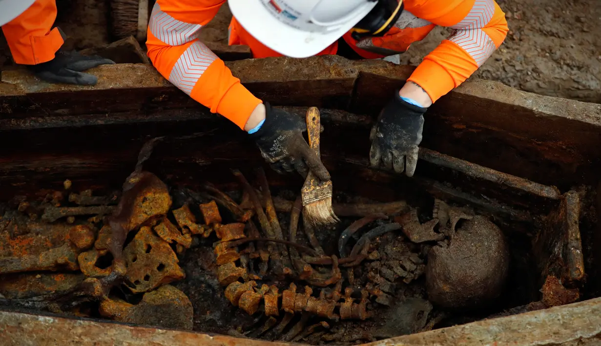 Arkeolog membersihkan kerangka dalam peti mati saat penggalian pemakaman di bawah St James Gardens, London, Inggris, Kamis (1/11). Lokasi pemakaman berada dekat Stasiun Euston. (ADRIAN DENNIS/AFP)
