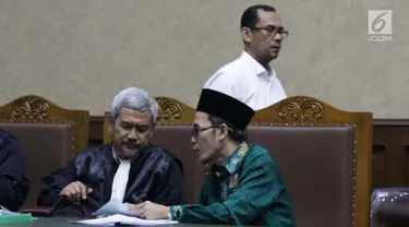 Terdakwa dugaan suap seleksi pengisian jabatan di Kementerian Agama, Haris Hasanuddin (berdiri) dan M Muafad Wirahadi (kanan duduk) saat jeda sidang lanjutan di Pengadilan Tipikor, Jakarta, Rabu (10/7/2019). Sidang mendengar keterangan saksi. (Liputan6.com/Helmi Fithriansyah)
