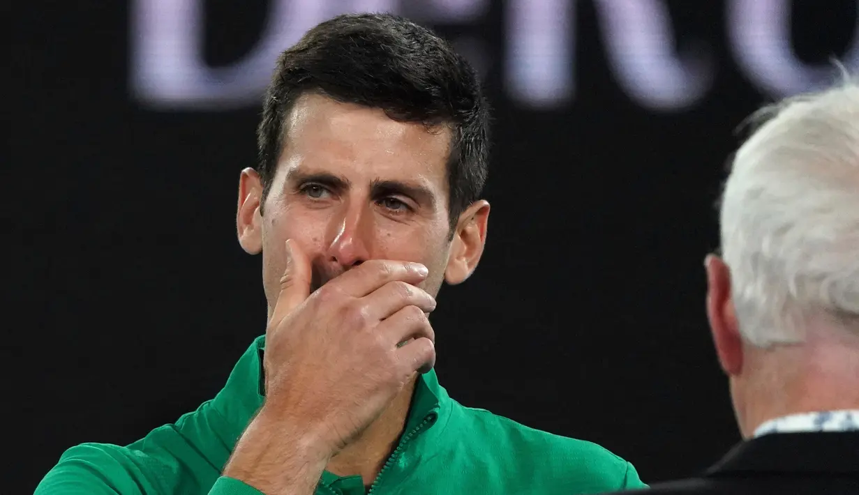 Reaksi Novak Djokovic saat diwawancarai tentang kematian Kobe Bryant usai mengalahkan Milos Raonic pada perempat final Australia Terbuka di Melbourne, Selasa (28/1/2020). Djokovic mengenakan jaket dengan inisial dan nomor punggung Kobe Bryant untuk menghormati temannya itu. (AP Photo/Lee Jin-man)