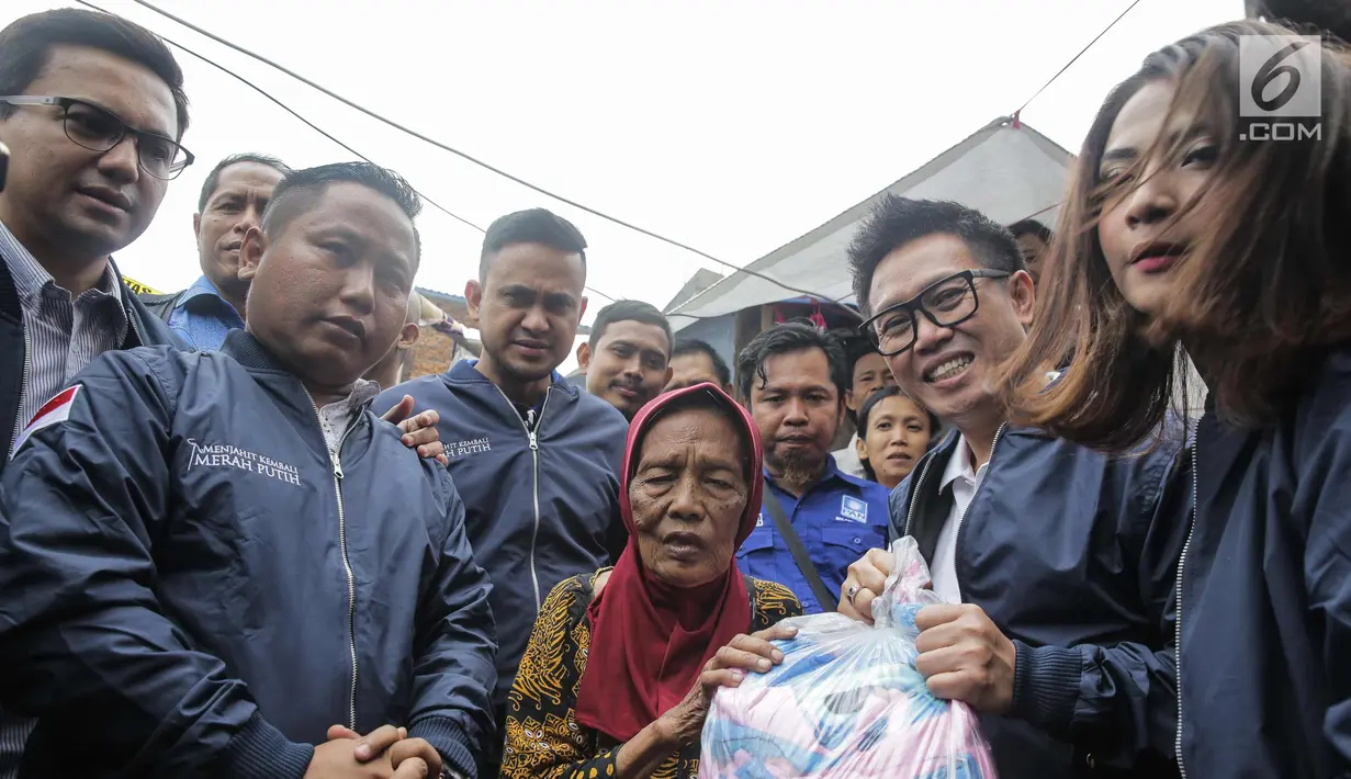 Artis sekaligus Ketua DPW PAN DKI Jakarta Eko Patrio bersama para pekerja seni saat memberi bantuan ke salah satu warga saat menyambangi lokasi kebakaran di Taman Sari, Jakarta, Senin (5/2). (Liputan6.com/Faizal Fanani)
