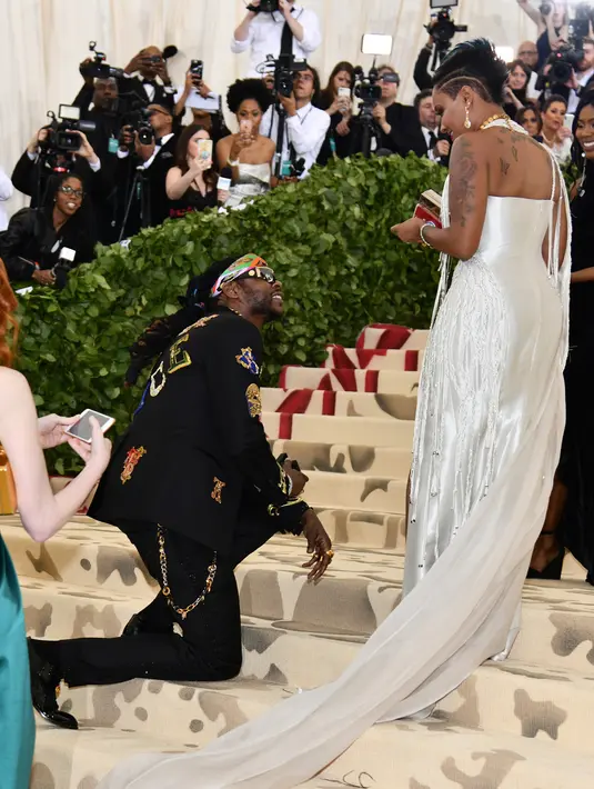 Rapper 2 Chainz berlutut saat melamar sang kekasih, Kesha Ward pada Met Gala 2018 di Metropolitan Museum of Art, New York, Senin (7/5). Chainz berlutut di karpet putih Met Gala untuk melingkarkan cincin di jari manis Kesha. (Charles Sykes/Invision/AP)