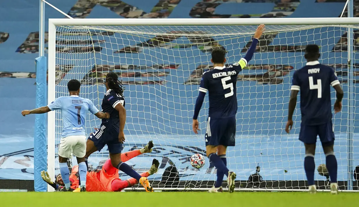 Pemain Manchester City Raheem Sterling (kiri) mencetak gol ke gawang Olympiacos pada pertandingan Grup C Liga Champions di Etihad Stadium di Manchester, Inggris, Selasa (3/11/2020). Manchester City mencukur Olympiacos dengan skor 3-0. (AP Photo/Dave Thompson)