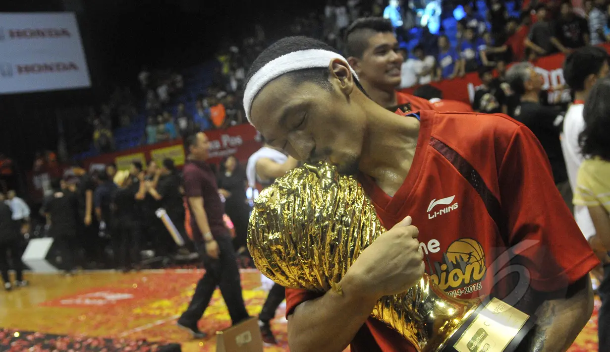 Pemain Satria Muda Britama Erick Sebayang kegirangan mencium piala NBL Indonesia 2015 usai mengalahkan Pelita Jaya Energi-MP, Jakarta, Minggu (10/5/2015). Satria Muda Britama unggul 62-54 atas Pelita Jaya Energi-MP. (Liputan6.com/Herman Zakharia)
