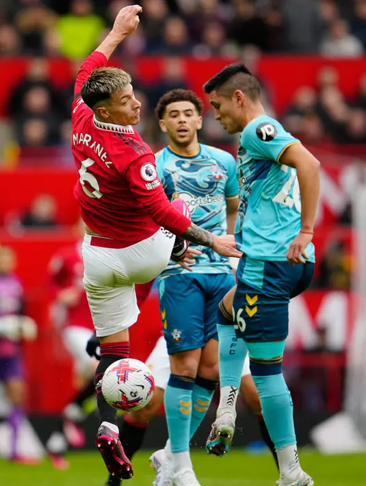 Pemain Manchester United Lisandro Martinez (kiri) berebut bola dengan pemain Southampton Carlos Alcaraz pada pertandingan sepak bola Liga Inggris di Stadion Old Trafford, Manchester, Inggris, 12 Maret 2023. Pertandingan berakhir imbang dengan skor 0-0. (AP Photo/Jon Super)