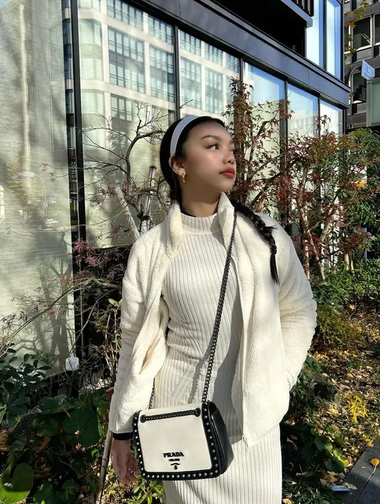Kombinasi knitted bodycon dress dan wol jacket serba putih jadi salah satu andalan outfit liburan Naura Ayu di Jepang. Penampilannya kian manis dengan bandana warna putih dan sling bag nuansa monokrom. [@naura.ayu]