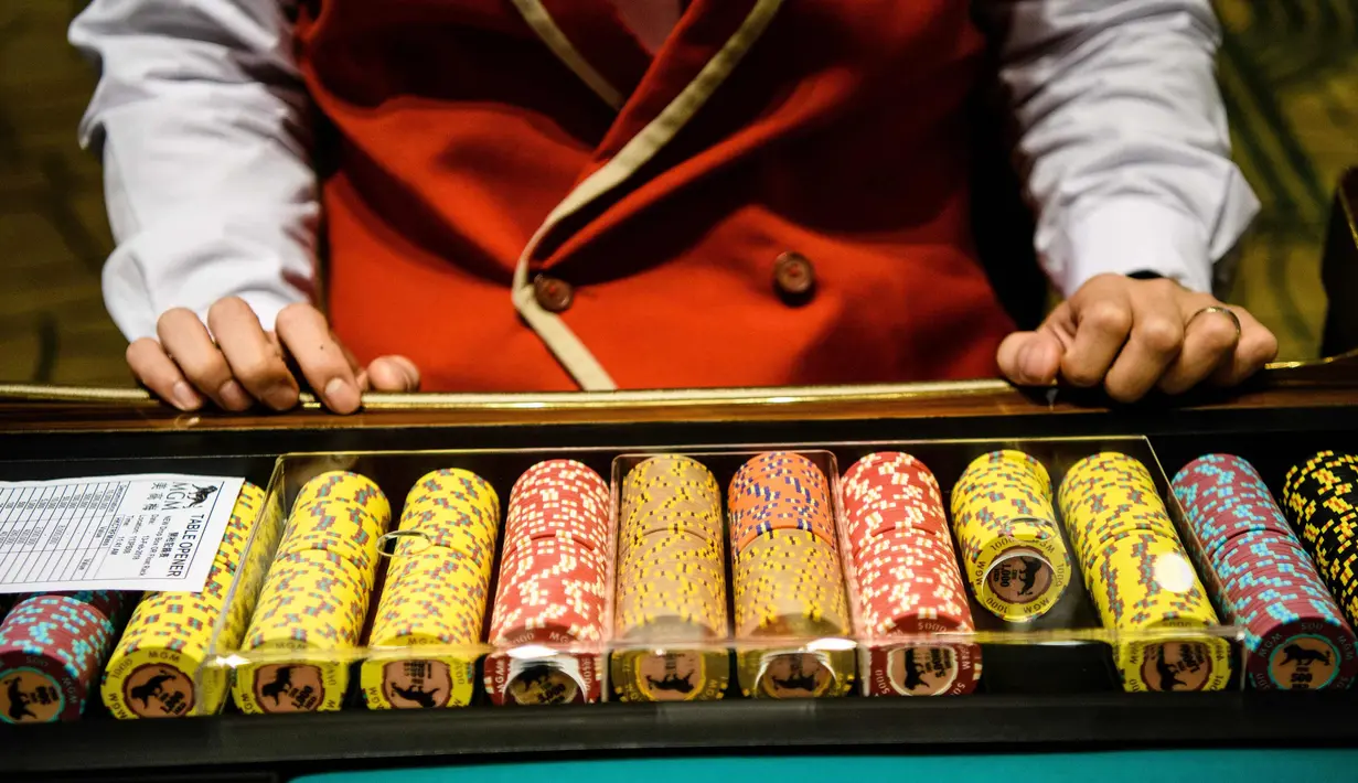 Anggota staf menyiapkan koin untuk berjudi di kasino resor MGM Cotai di Macau (13/2). MGM China membuka resor mega multi-miliar dolar baru di strip Cotai yang mewah di Macau pada tanggal 13 Februari. (AFP Photo/Anthony Wallace)