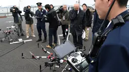 Petugas kepolisian menyiapkan drone yang dilengkapi jaring saat latihan penanggulangan anti terorisme di Tokyo, Jepang, Minggu (17/1). Latihan yang diikuti 400 petugas kepolisian dan keamanan ini untuk persiapan acara Tokyo maraton (AFP/Toshifum Kitamura)