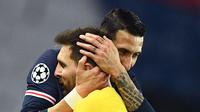 Gelandang PSG, Angel Di Maria (kanan) memeluk penyerang Barcelona Lionel Messi setelah pertandingan leg kedua babak 16 besar Liga Champions di stadion Parc des Princes di Paris, Kamis (11/3/2021). PSG lolos ke perempatfinal meski hanya bermain imbang 1-1 dengan Barcelona di leg II. (AFP/Franck Fife)