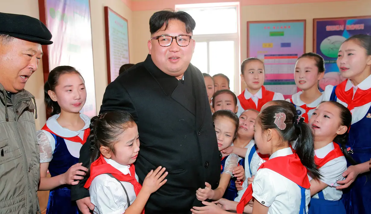 Ekspresi Kim Jong-un saat sejumlah anak memeluk diri saat berkunjung ke Samjiyon (28/11). Puluhan anak sekolah histeris kegirangan saat bertemu dengan pemimpin negara mereka. (REUTERS/KCNA)