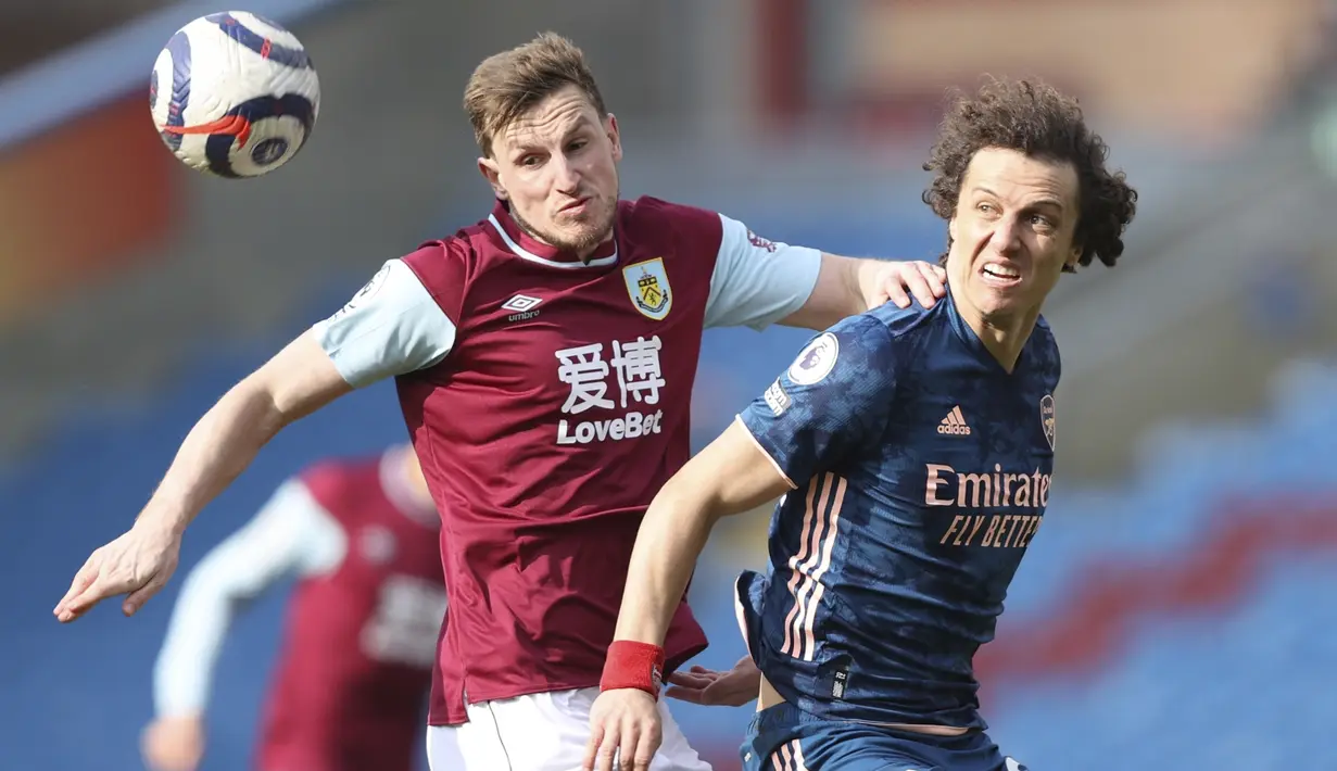 Bek Arsenal, David Luiz (kanan) berebut bola dengan striker Burnley, Chris Wood dalam laga lanjutan Liga Inggris 2020/21 di Turf Moor, Burnley, Sabtu (6/3/2021). Arsenal bermain imbang 1-1 dengan Burnley. (AP/Clive Brunskill/Pool)