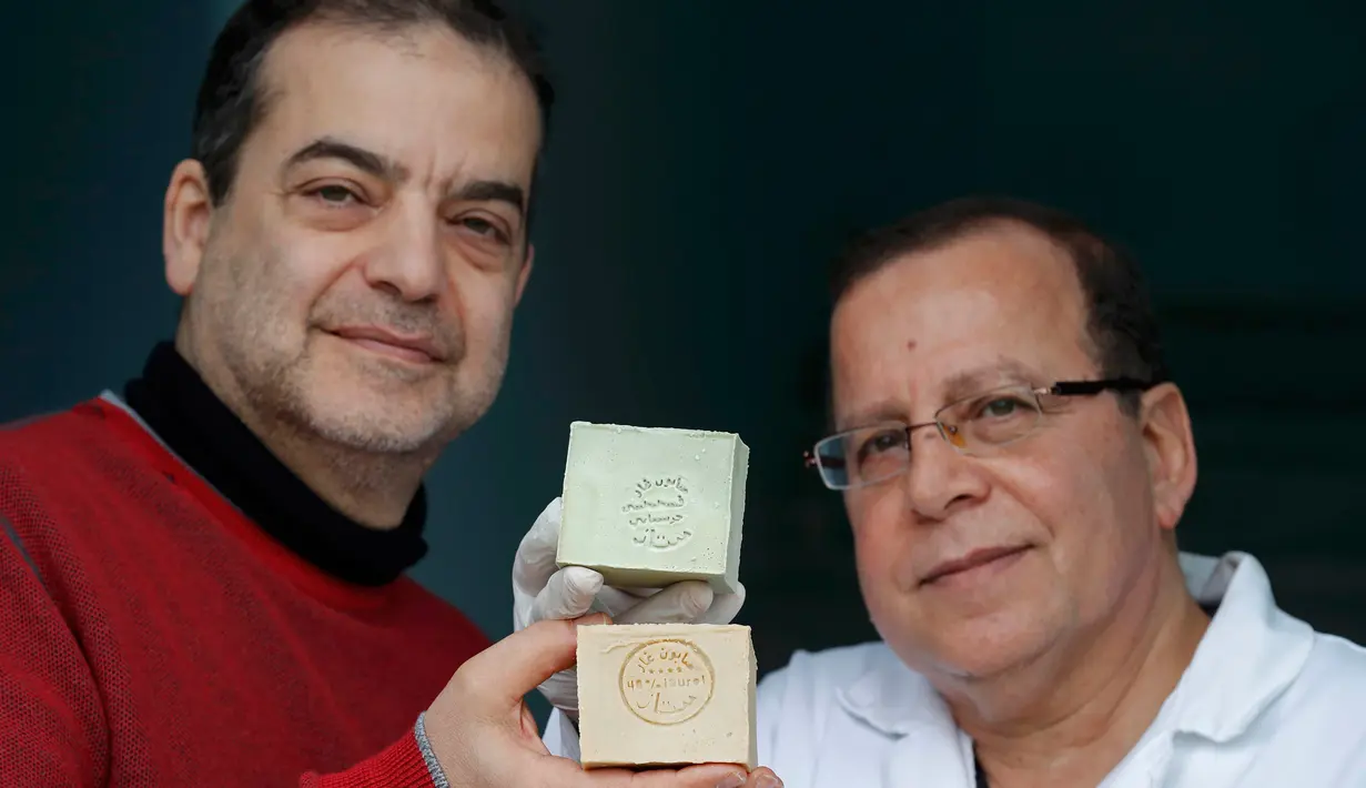 Samir Constantini bersama rekannya menunjukkan sabun khas Aleppo, Santeny, Paris, Kamis (22/12). Kota Aleppo yang sedang perang membuat dirinya memindahkan produksi sabun ke Perancis. (REUTERS / Christian Hartmann)