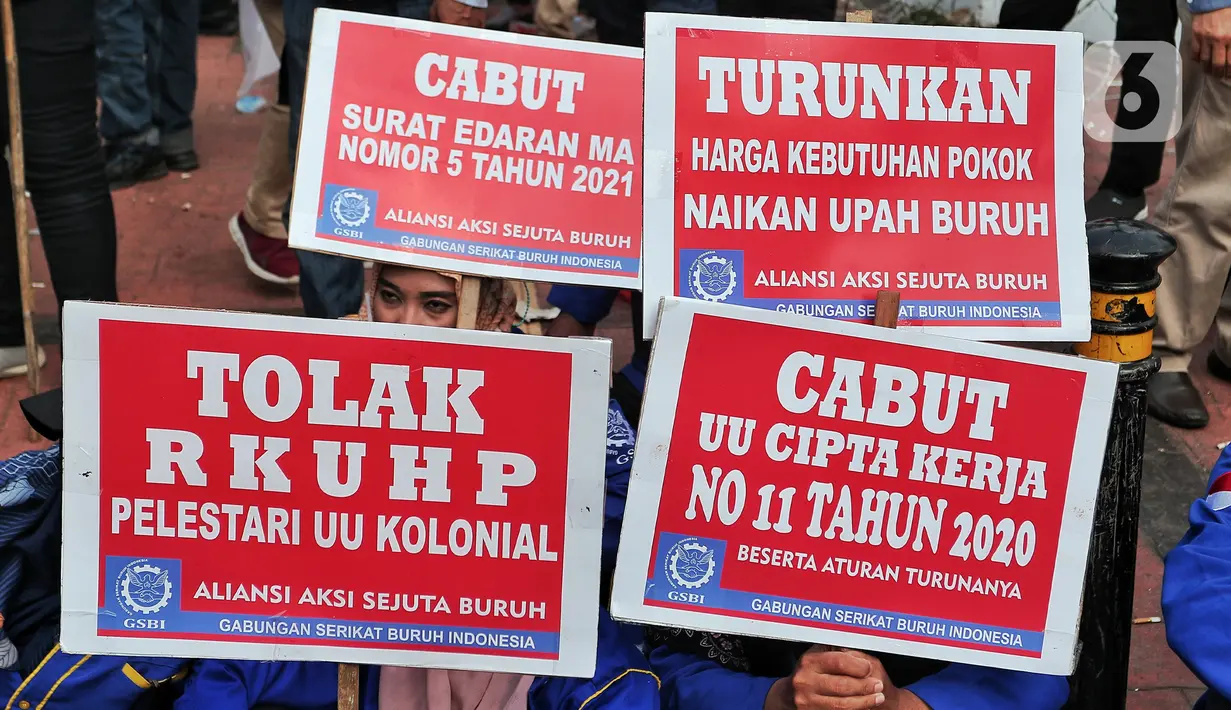 Sejumlah buruh membawa poster bertuliskan tuntutan saat melakukan unjuk rasa di depan Gedung DPR, Jakarta, Rabu (10/8/2022). Dalam aksi tersebut mereka menuntut agar pemerintah menghapus Omnibus Law. (Liputan6.com/Angga Yuniar)