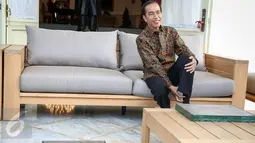 Presiden Joko Widodo melepaskan kaos kakinya untuk melakukan proses pencetakan kaki di Istana Merdeka, Jakarta, Selasa (13/10/2015). Cetakan tersebut akan diletakkan di Taman Pintar Yogyakarta. (Liputan6.com/Faizal Fanani)