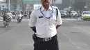 Polisi lalu lintas India Ranjeet Singh berpose saat berdiri di tengah jalan persimpangan Indore, India (22/12). Ranjeet Singh memiliki kumis bergaya Freddie Mercury namun suka menari moonwalk ala Michael Jackson. (AFP Photo/Indranil Mukherjee)