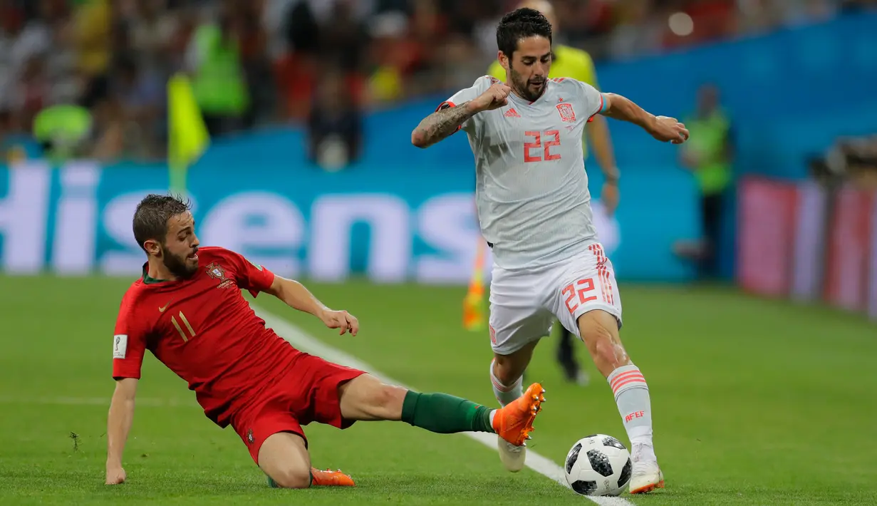 Gelandang Spanyol, Isco berusah membawa bola melewati pemain Portugal Bernardo Silva saat bertanding pada grup B Piala Dunia 2018 di Stadion Fisht di Sochi, Rusia (15/6). Portugal dan Spanyol bermain imbang 3-3. (AP Photo/Sergei Grits)
