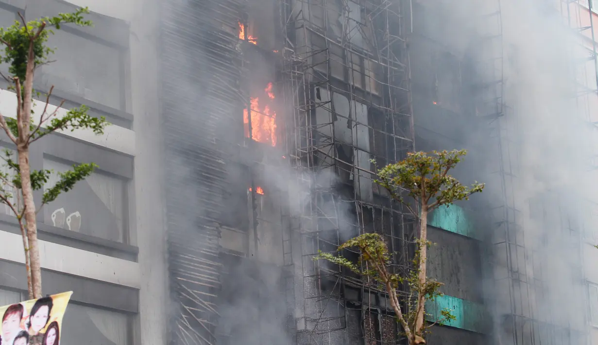 Kobaran api dan kepulan asap terlihat dari salah satu ruangan tempat karaoke di ibu kota Vietnam, Hanoi, Selasa (1/11). Si jago merah dengan cepat menyebar ke gedung-gedung di dekat tempat karaoke itu. (STR / AFP)