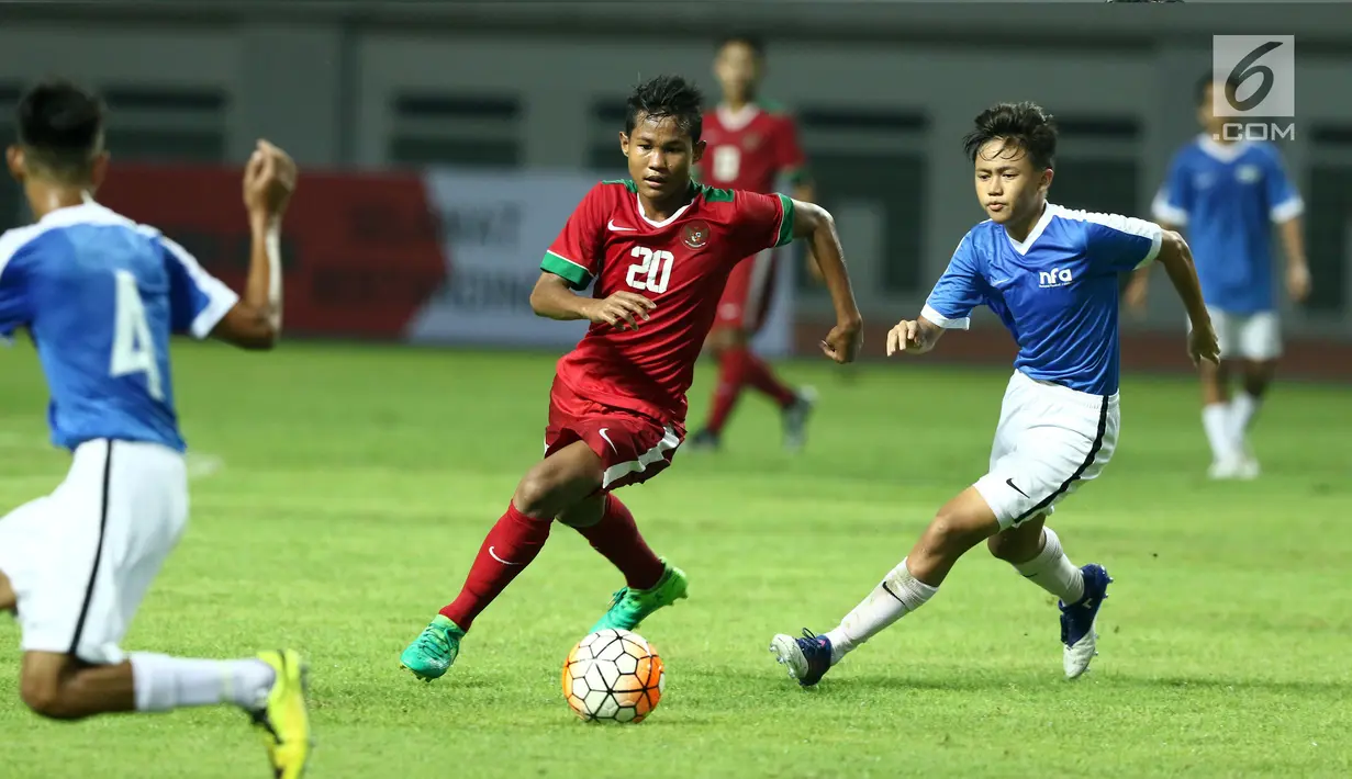 Penyerang Timnas Indonesia U-16, Amirudin Bagus Kahfi (tengah) mencoba melewati kawalan pemain Singapura U-16 saat laga persahabatan di Stadion Wibawa Mukti, Kab Bekasi, Kamis (8/6). Indonesia U-16 menang telak 4-0. (Liputan6.com/Helmi Fithriansyah)