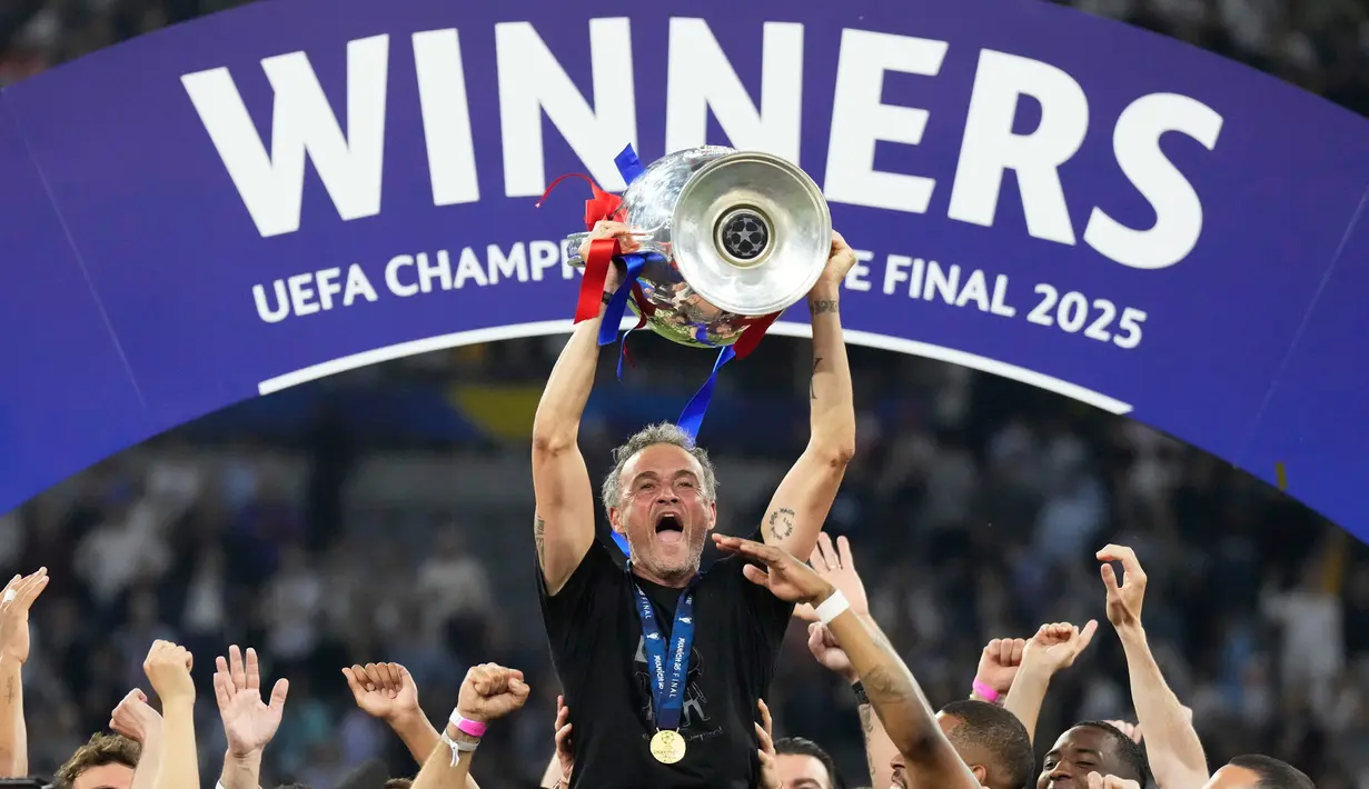 Pelatih PSG, Luis Enrique, mengangkat trofi Liga champions 2024/2025 di Stadion Allianz Arena, Minggu (01/06/2025) dini hari WIB. (AP Photo/Matthias Schrader)