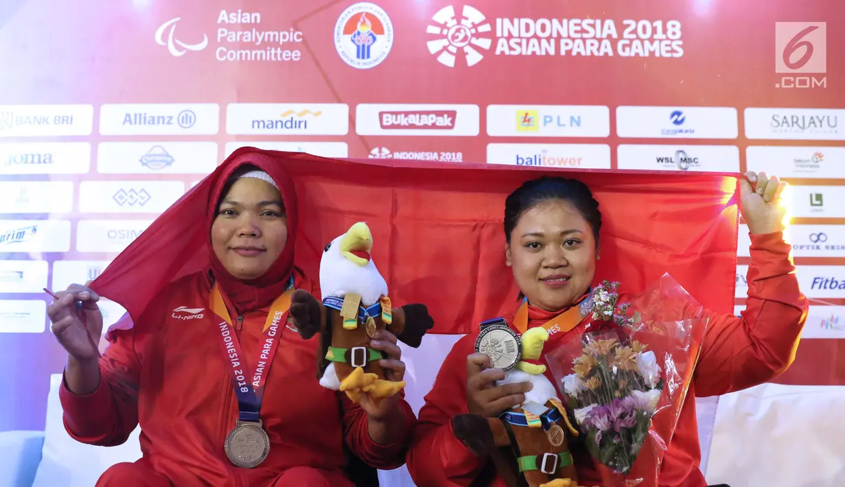 Atlet Para Powerlifting Indonesia, Nurtani Purba (kiri) bersama Siti Mahmudah usai laga di kelas Womens Up 73 dan 79kg Asian Para Games 2018 di Jakarta, Rabu (10/10). Keduanya berhasil meraih perak. (Liputan6.com/Helmi Fithriansyah)