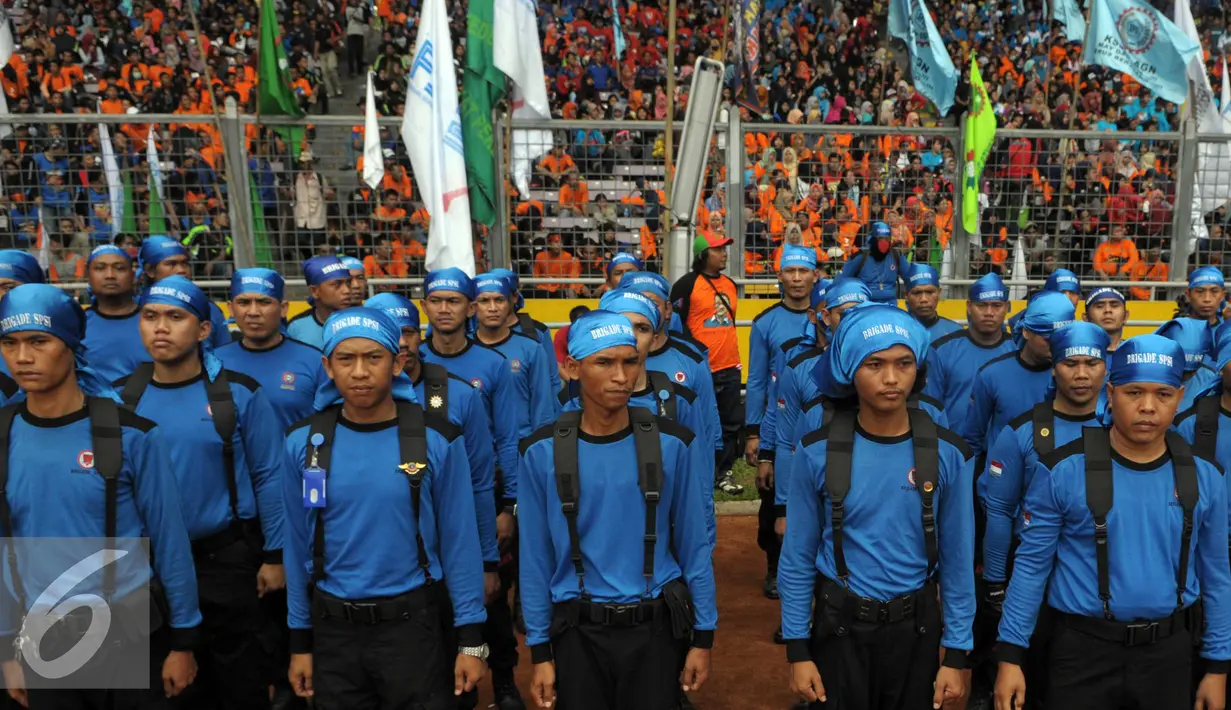 Sejumlah buruh mengenakan baju biru berbaris di GBK, Jakarta, Minggu (1/5) GBK merupakan titik kumpul para Buruh dalam penyampaian aspirasi buruh saat Perayaan Buruh Internasional. (Liputan6.com/Helmi Afandi)