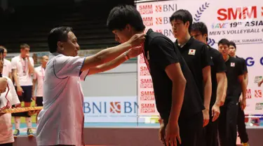 Ketua PBVSI, Imam Sudjarwo mengalungkan medali kepada pemain timnas Jepang usai gelaran Kejuaraan Voli Putra Asia 2017 di GOR Tri Dharma, Gresik, Selasa (1/8). Jepang menjadi kampiun usai menumbangkan Kazakhstan 3-1. (Liputan6.com/Helmi Fithriansyah)