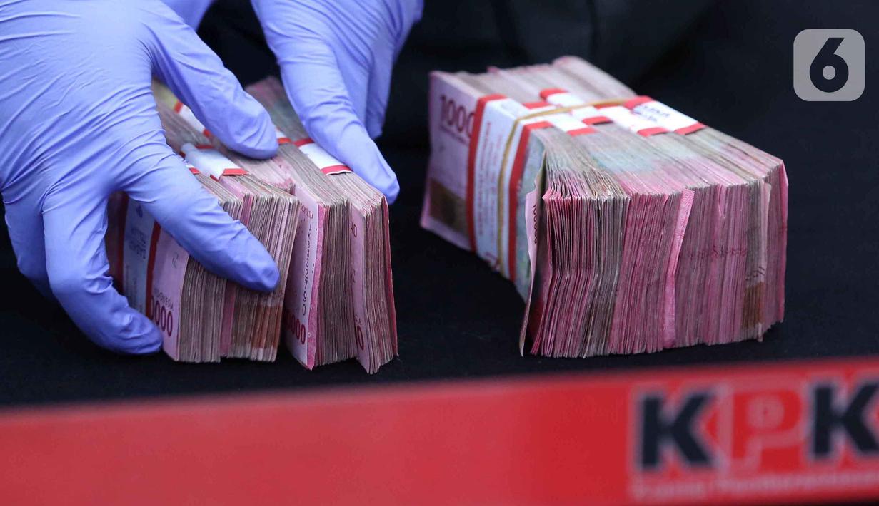 Dari tujuh terduga yang ditangkap, KPK menetapkan lima orang tersangka terkait terkait penerimaan atau janji dalam pengurusan sengketa lahan di Pengadilan Negeri (PN) Depok. Tampak dalam foto, petugas menata uang barang bukti hasil Operasi Tangkap Tangan (OTT) terduga pelaku tindak pidana korupsi terkait penerimaan atau janji dalam pengurusan sengketa lahan di Pengadilan Negeri Depok di gedung Merah Putih Komisi Pemberantasan Korupsi (KPK), Jakarta, Jumat (6/2/2026). (Liputan6.com/Helmi Fithriansyah)