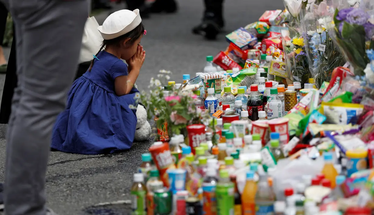 Seorang gadis berdoa usai memberikan bunga untuk korban Penikaman Massal yang terjadi di Kawasaki, Jepang (29/5/2019). Seorang siswi dan seorang pria dewasa tewas dan 17 siswi lainnya cedera akibat penikaman massal di Kota tersebut. (Reuters/Issei Kato)