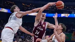Pemain timnas basket Latvia, Andrejs Grazulis (tengah) tembakannya diblok oleh pebasket Jerman Franz Wagner (kiri) saat perempat final Piala Dunia Bola Basket di Manila, Filipina, Rabu, 6 September 2023. (AP Photo/Michael Conroy)
