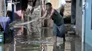 Warga menjala ikan saat banjir menggenangi kawasan Rawa Terate, Cakung Jakarta, Rabu (30/1). Banjir yang mencapai ketinggian pinggang orang dewasa terjadi sejak dini hari. (merdeka.com/Iqbal S. Nugroho)