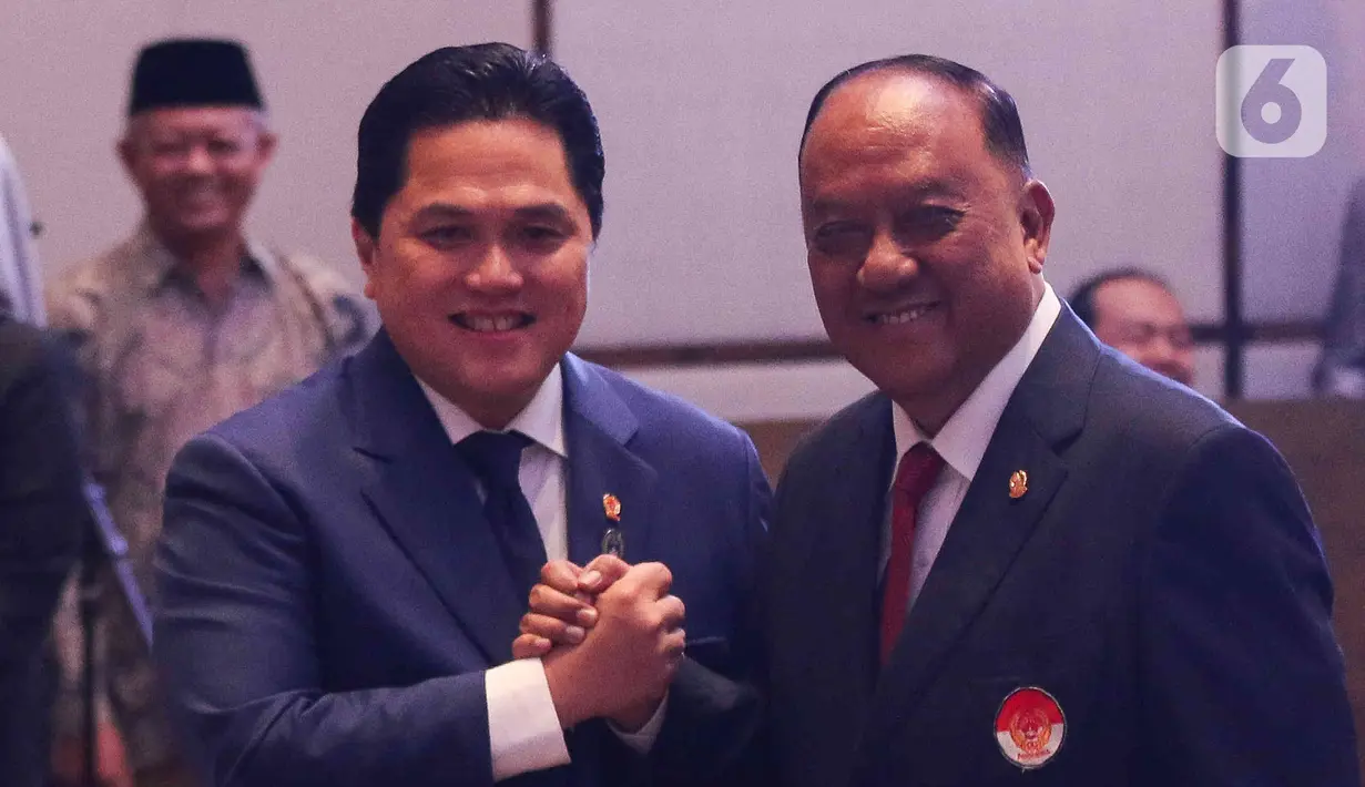 Ketua KONI Pusat Marciano Norman (kanan) berjabat tangan dengan Ketua Umum PSSI Erick Thohir (kiri) saat pengukuhan dan pelantikan pengurus PSSI masa bakti 2023-2027 di Jakarta, Jumat (26/5/2023). (Liputan6.com/Herman Zakharia)
