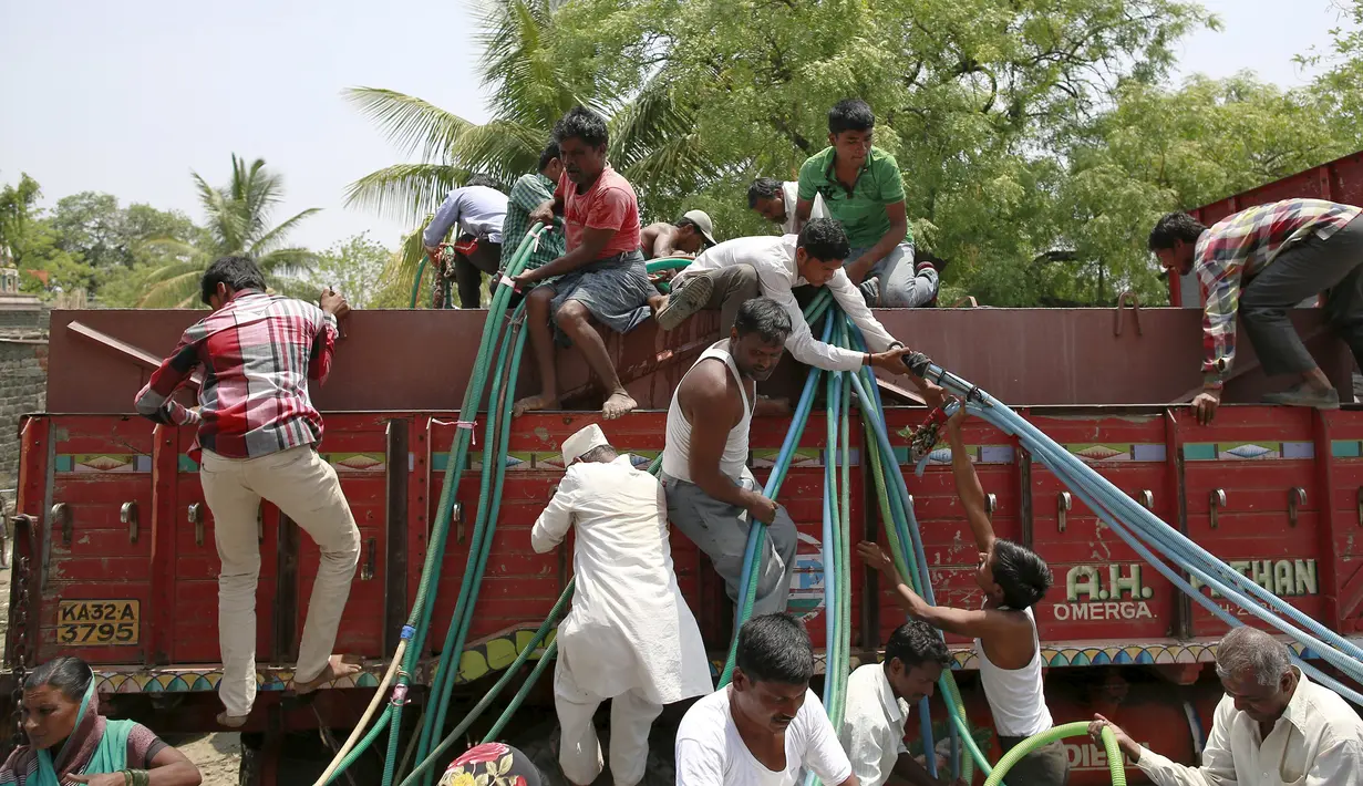 Warga mengambil air dari truk tangki bantuan dari pemerintahannya di Desa Masurdi, Latur, India (17/4). Sejumlah wilayah di India mengalami kesulitan air bersih karena kekeringan akibat kemarau panjang melanda negerinya. (REUTERS/Danish Siddiqui)