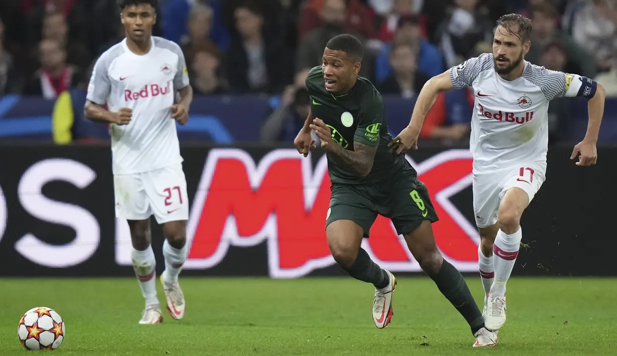 Gelandang Wolfsburg , Aster Vranckx (kiri) membawa bola dari kejaran pemain RB Salzburg, Andreas Ulmer pada pertandingan Grup G Liga Champions di stadion Salzburg, Austria, Rabu (20/10/2021). Kini Salzburg berada diperingkat pertama klasemen dengan tujuh poin. (AP Photo/Matthias Schrader)