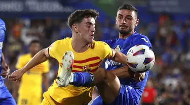 Gelandang Barcelona Gavi dan bek  Getafe, Juan Iglesias berebut bola pada pekan perdana La Liga 2023/2024 di Coliseum Alfonso Perez, Senin (14/08/2023) dini hari WIB. (AP Photo/Alvaro Medranda)