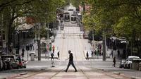 Orang-orang melintasi Bourke Street di Melbourne, Australia, Kamis (30/9/2021). Infeksi Covid-19 di Melbourne melonjak ke level rekor dengan sebanyak 1.438 infeksi baru ditemukan di kota terbesar kedua Australia itu. (Daniel Pockett/AAP Image via AP)