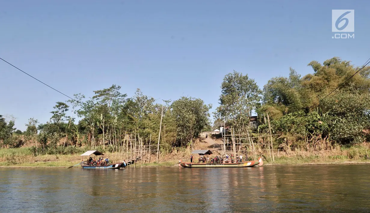 Pemandangan saat warga menaiki perahu eretan atau tambangan menyeberangi Sungai Brantas, Desa Mayan, Mojo, Kediri, Sabtu (29/9). Perahu eretan biasanya mengangkut petani, siswa, hingga pengendara sepeda motor. (Merdeka.com/Iqbal Nugroho)