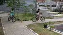 Dua anak bermain sepeda di sekitar RPTRA Tiga Durian, Jakarta, Selasa (15/5). Menurut Sandiaga Uno ada 290 ruang terbuka hijau (RTH) dan tahun ini akan tambah 47 RTH lagi. (Liputan6.com/Immanuel Antonius)