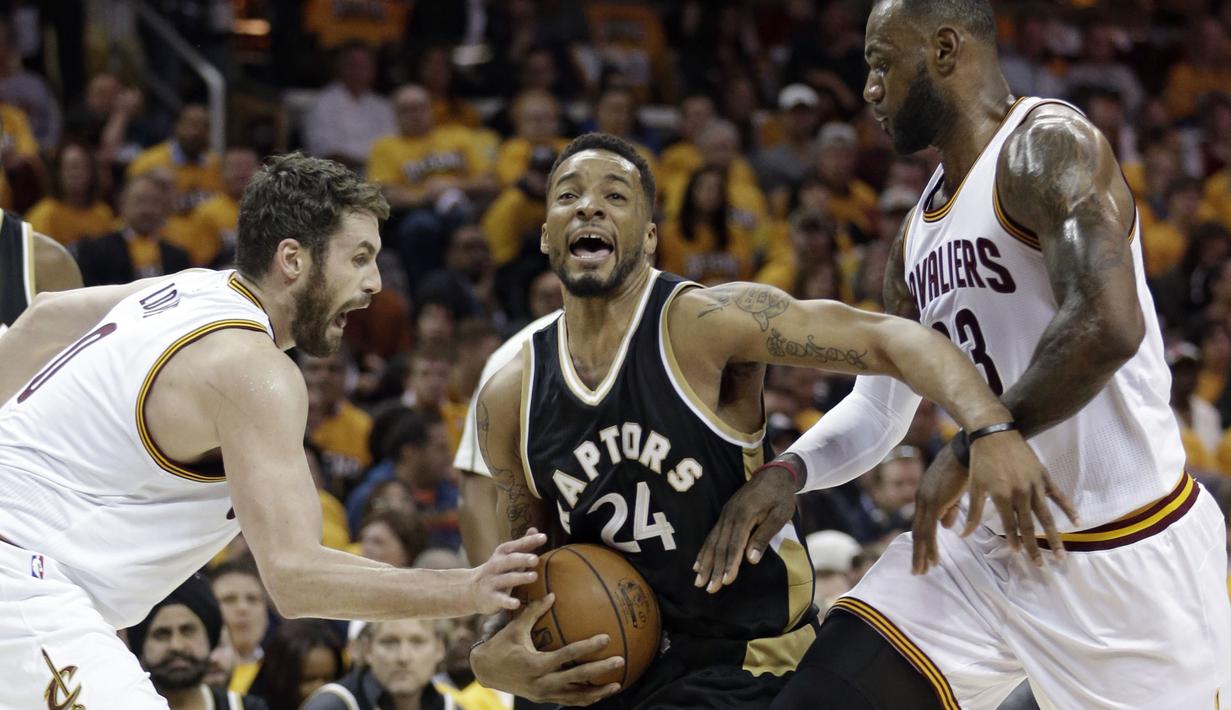 Pemain Toronto Raptors, Norman Powell (tengah) berusaha keluar dari adangan LeBron James (kanan) pada Game 2 semifinal Eastern Conference NBA basketball playoff series di Quicken Loans Arena, (3/5/2017). Cavs menang 125-103. (AP/Tony Dejak)